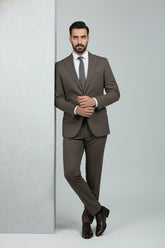 Man in brown three-piece suit with waistcoat, tailored fit for formal occasions.